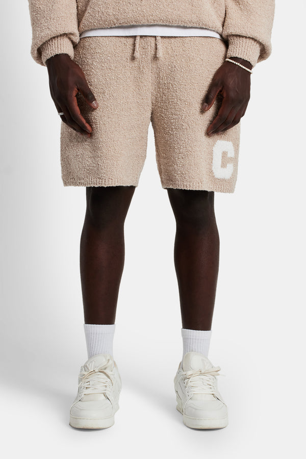 Male model wearing the textured knitted short in beige
