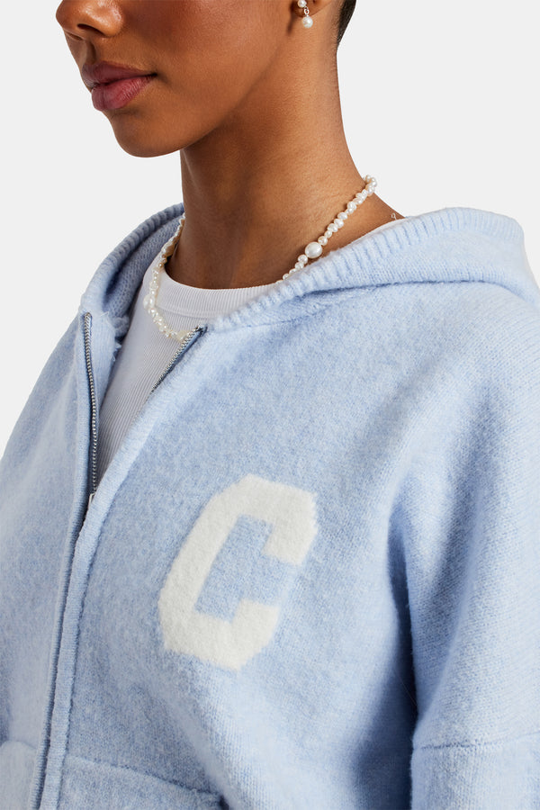 female model wearing the hooded zip through knitted jumper in light blue