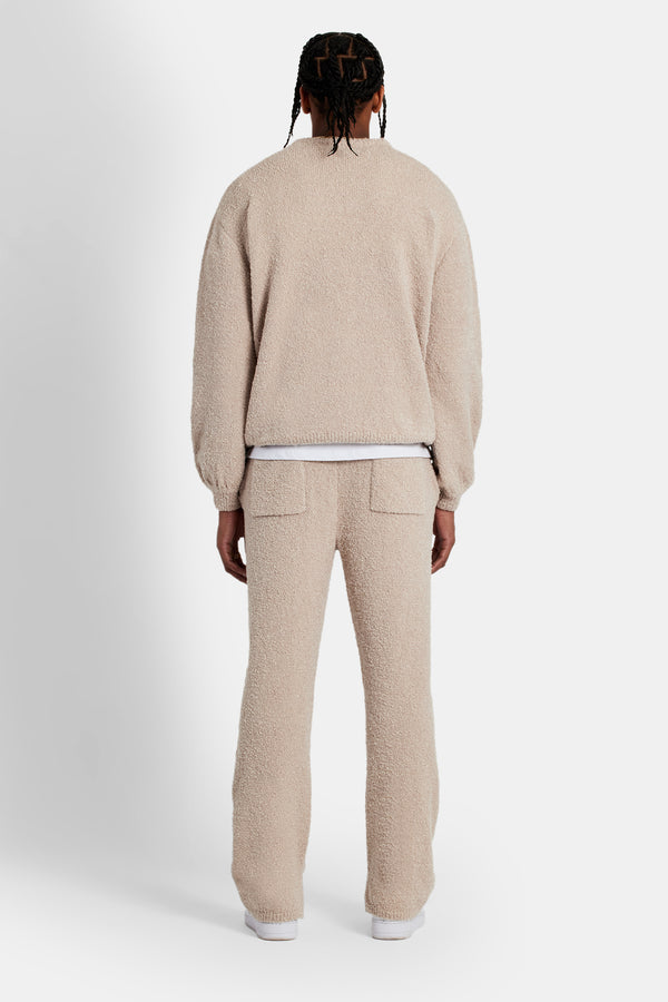 male model wearing the texured knitted sweater tracksuit in beige