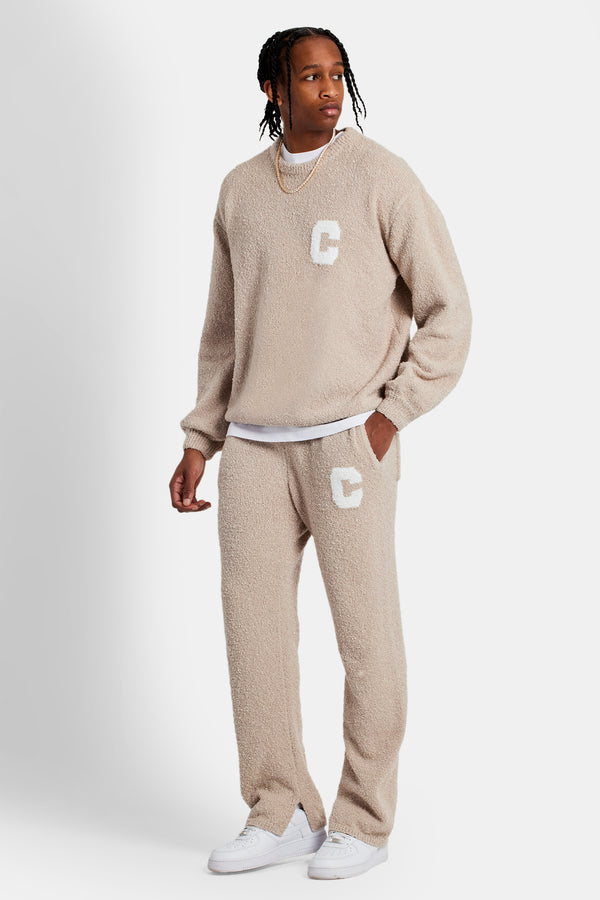 male model wearing the texured knitted sweater tracksuit in beige 