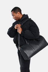 Male model carrying the black leather duffle bag