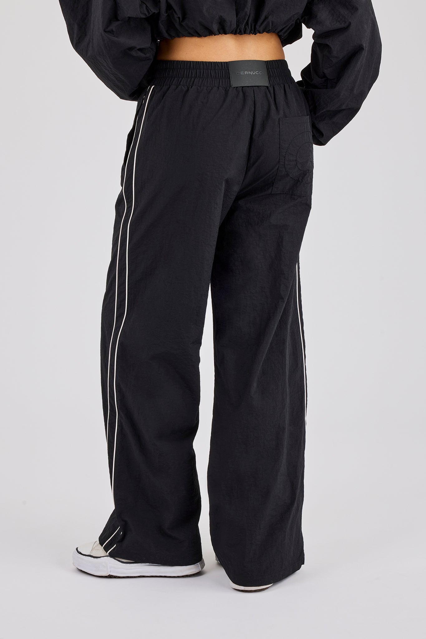 Jogginghose mit weitem Bein und Crinkle-Nylon-Paspelierung – Schwarz