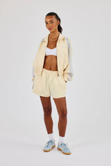 Taping Cropped Funnel-Neck Jacke & Taping Shorts – Buttergelb