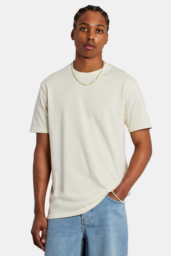Male model wearing the cernucci t-shirt in the colour ecru