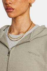 close up of model wearing sage zip through hoodie with cernucci logo 