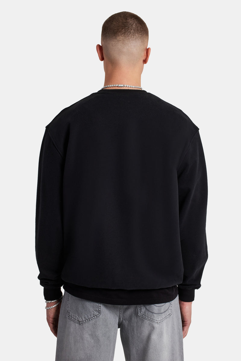 Male Model wearing black sweater with embellished C detail